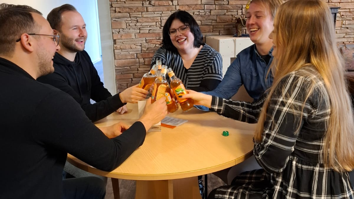 5 Personen an einem Tisch mit Getränken